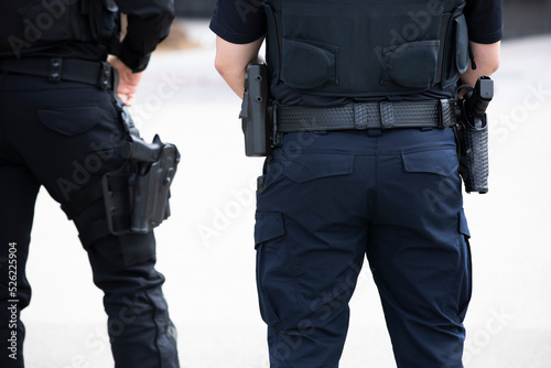 Daytime view of a white police officer's utility belt and gun holster. © Matt Gush