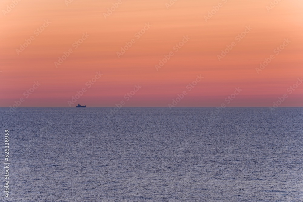 能登半島で見た夕焼けに染まる日本海を進む貨物船の情景＠石川