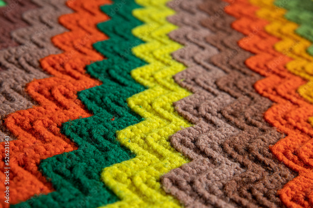 Fototapeta premium close-up of grandma's retro zigzag striped blanket, crocheted or knitted, grandma's house, cozy and warm