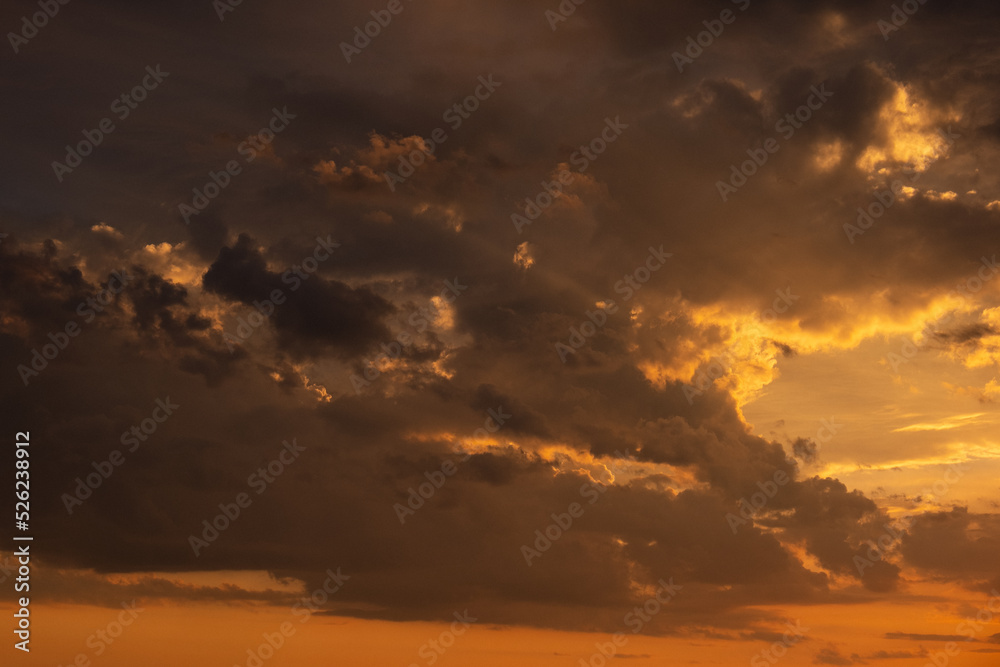 A beautiful sunset with gold, red, yellow and orange sunlight passing through many clouds of different hues. Horizontal photo. Nature. Sky. Cloudy. Background. A beautiful sunset with gold, red, yellow and orange sunlight passing through many clouds of different hues. Horizontal photo. Nature. Sky. Cloudy. Background.