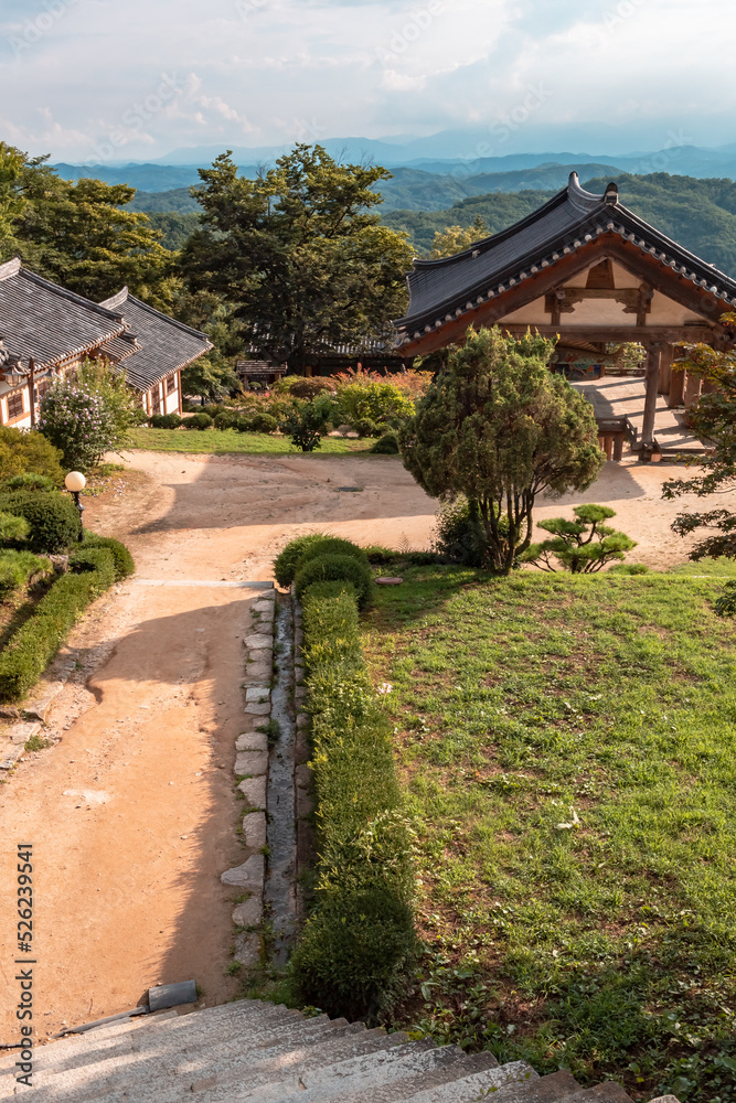 Traditional Korean architecture and lush green forest and mountains at Buseoksa Buddhist temple complex in South Korea on a cloudy day	