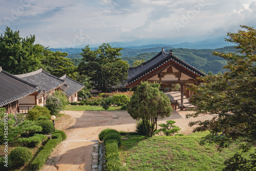 Traditional Korean architecture and lush green forest and mountains at Buseoksa Buddhist temple complex in South Korea on a cloudy day 