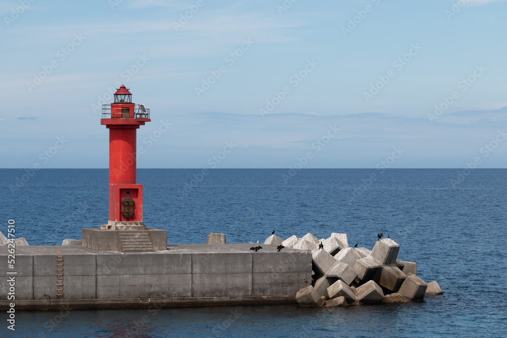 A red lighthouse at port harbour entrance
