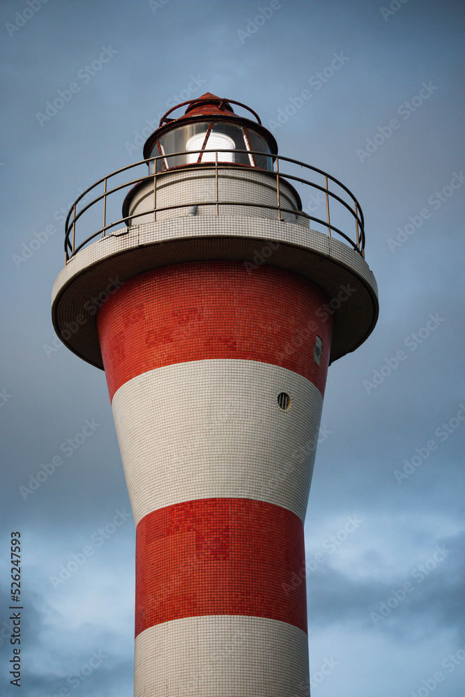 LED light shining on a red and white lighthouse