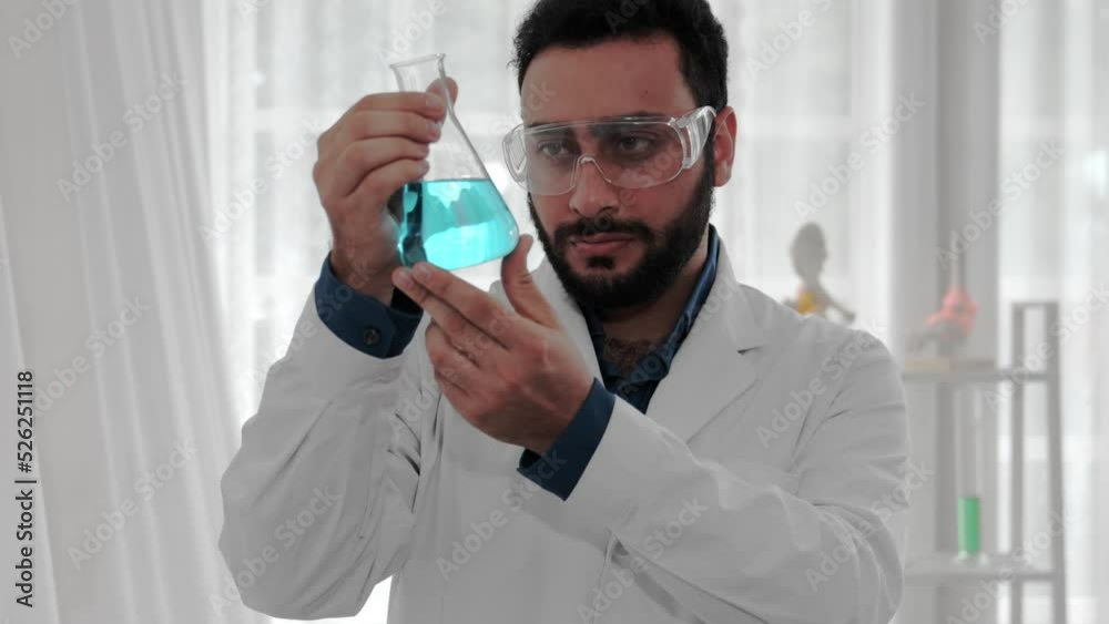 Scientist of laboratory researcher holding medical glass bottle. Analysing Chemicals in Laboratory with test tubes. Scientist looking at flask for analysis medical for chemistry development Scientist of laboratory researcher holding medical glass bottle. Analysing Chemicals in Laboratory with test tubes. Scientist looking at flask for analysis medical for chemistry development