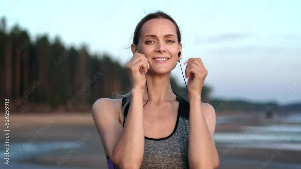 Portrait athletic woman jogging running in music earphones healthy lifestyle at sunset beach closeup Portrait athletic woman jogging running in music earphones healthy lifestyle at sunset beach closeup