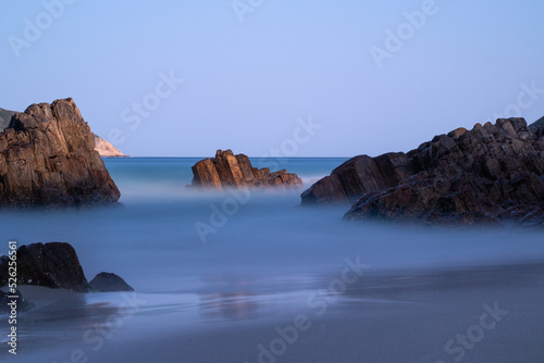 Long exposure at the beach. Long exposure photograph at a beach makes the sea silky smooth around some rocks.
