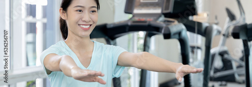 Beautiful and shapely Asian woman working out in the gym, Play exercise machine treadmill, Dumbbell, stretching, Hanging bar, Barbell, Cardio, Stretch, Woman warming up in the gym, Jump rope. photo