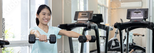 Beautiful and shapely Asian woman working out in the gym, Play exercise machine treadmill, Dumbbell, stretching, Hanging bar, Barbell, Cardio, Stretch, Woman warming up in the gym, Jump rope. photo