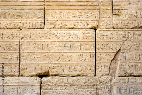 Ancient frescoes, hieroglyphs, images, symbols and of Egyptian gods on the wall of Karnak Temple complex (ancient Thebes). Luxor, Egypt. Copy space. Selective focus.