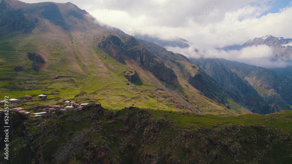 scenic drone shot of the small settlement in the Caucasus mountains, Kazbegi, Georgia. High quality photo
