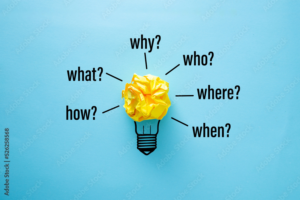 Crumpled paper on blue background with words when, why, what, who ...