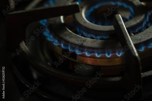 Detail of burning gas on the stove, rising gas prices,detail of a black gas stove, price growth, dirty black oven with a burn gas