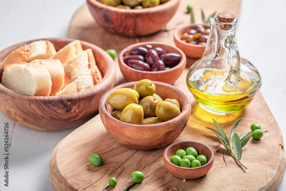 Healthy olives and extra virgin olive oil in wooden bowl.