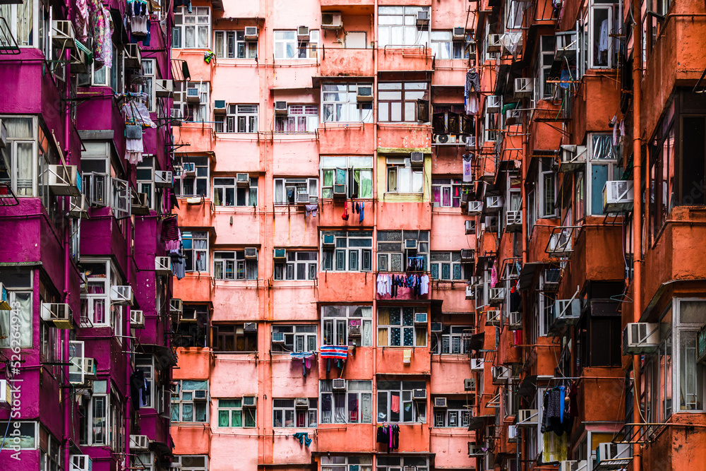 Monster building.  Purple and orange old residential compact vertical buildings in Hong Kong form a dead end street.