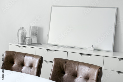 Weisse elektrische Infrarotheizung im Wohnraum mit Netzkabel und Thermostat photo