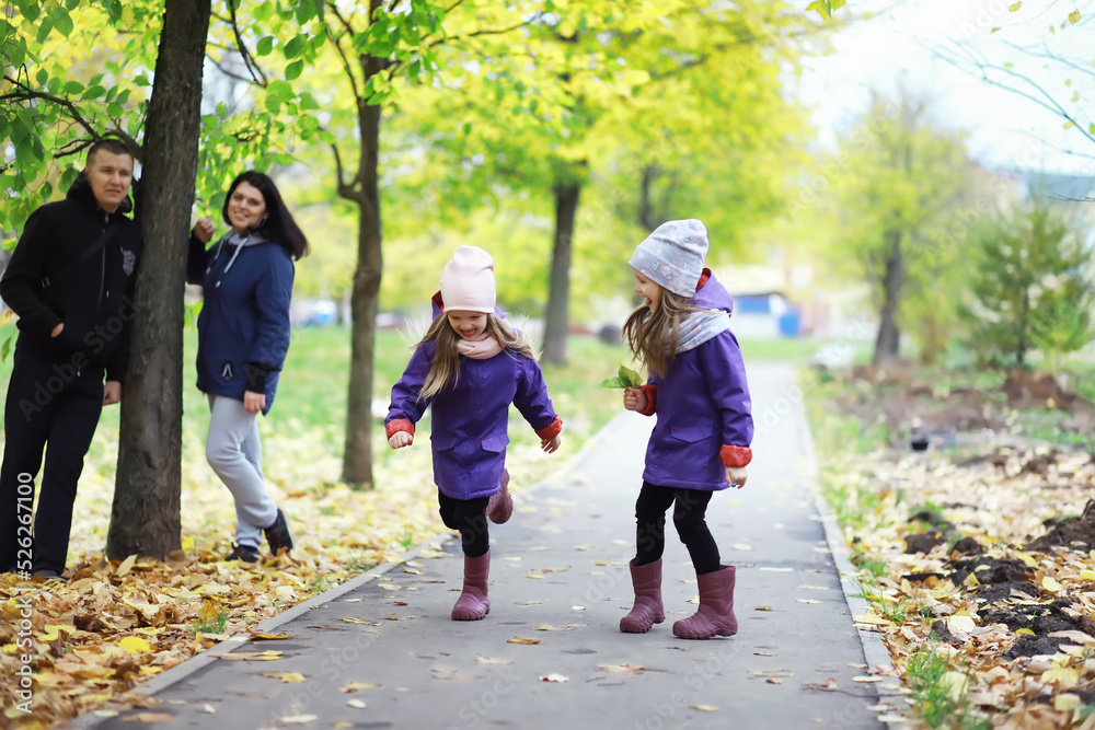 Fototapeta premium Leaf fall in the park. Children for a walk in the autumn park. Family. Fall. Happiness.