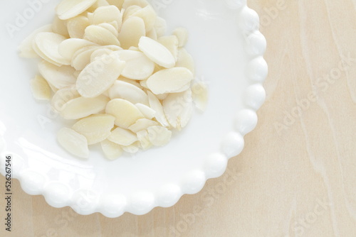 Sliced almond on white dish with copy space 
