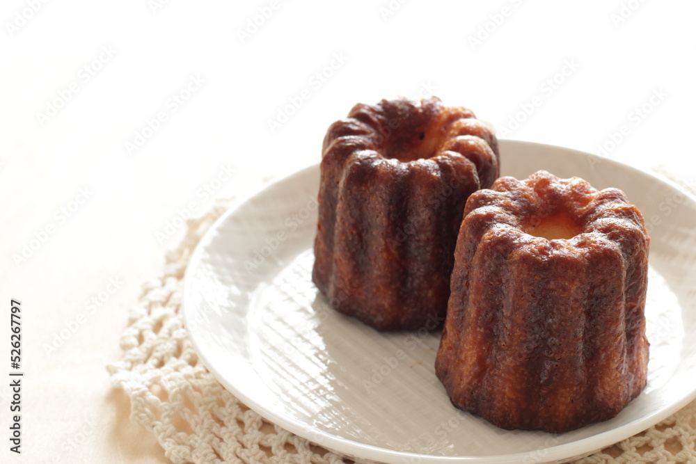 French confectionery, Canelé on dish for gourmet dessert French confectionery, Canelé on dish for gourmet dessert
