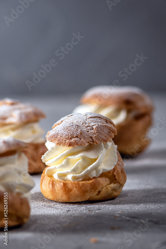 Homemade profiteroles with cream on light background photo