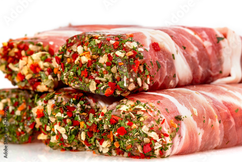 Bacon-wrapped meat roll with spices and herbs. Jamon pork, prosciutto, or presunto meat products, tartare meat inside. Meatloaf high focus view shallow depth of field on white isolated background