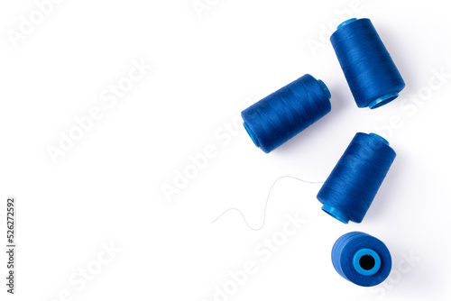 Spools of blue sewing thread lie randomly. Electric blue threads. Tailoring concept. Top view. Copy space