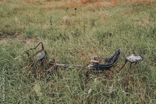 Old abandoned horse sledge abandoned in the high grass. photo