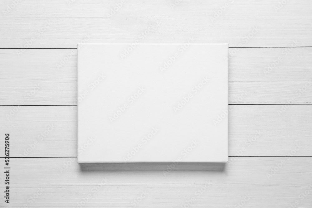 Blank canvas on white wooden background, top view. Space for design Blank canvas on white wooden background, top view. Space for design