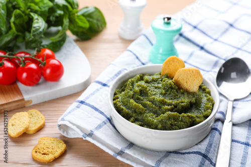 Bowl with tasty green puree and ingredients on wooden table