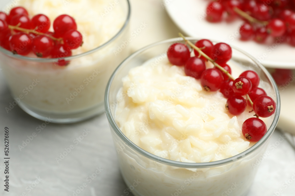 Delicious rice pudding with redcurrant on marble table, closeup Delicious rice pudding with redcurrant on marble table, closeup