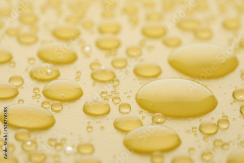 Water drops on yellow background, closeup view