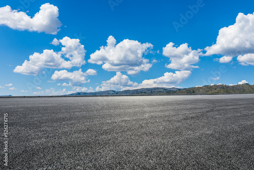Empty asphalt road and mountain nature scenery under blue sky © ABCDstock