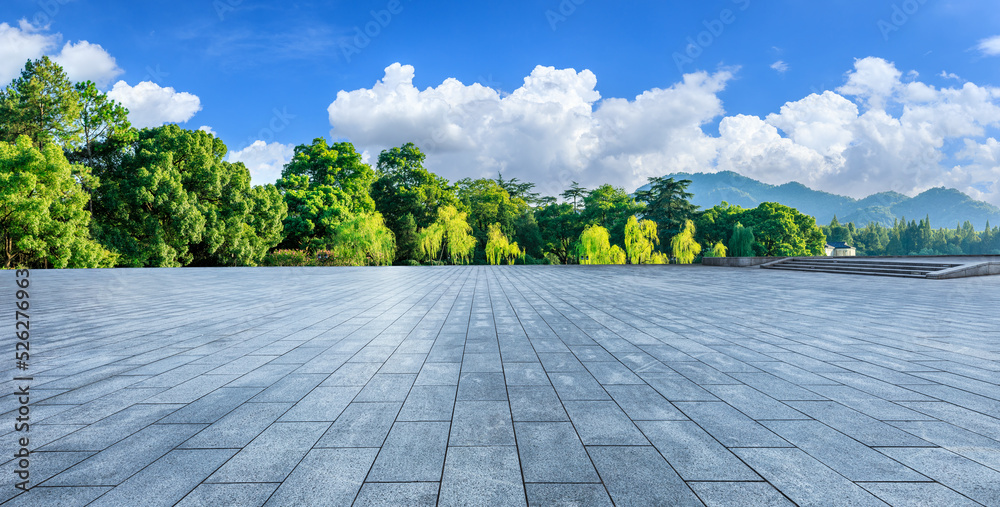 Empty square floor and green forest with mountain scenery under blue sky