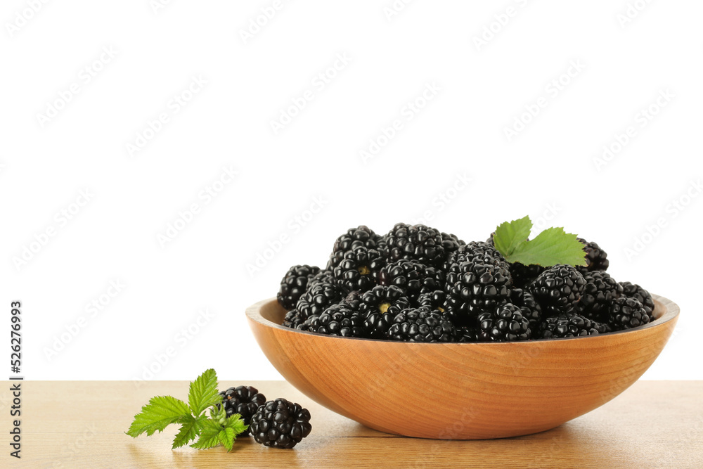 Bowl and fresh ripe blackberries on wooden table against white background, space for text Bowl and fresh ripe blackberries on wooden table against white background, space for text