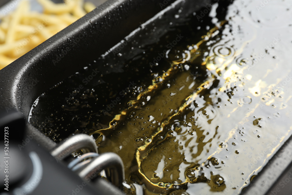 Hot cooking oil in deep fryer, closeup Hot cooking oil in deep fryer, closeup