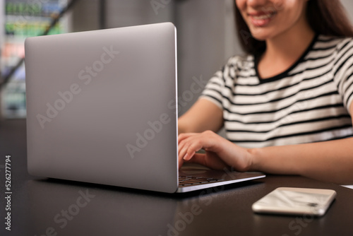 Young woman using laptop at table in hostel, closeup