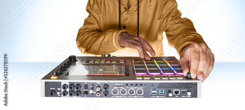 Professional musician playing in studio on a white background for a music video. Beatmaker hands on the drum machine close-up at the mpc.