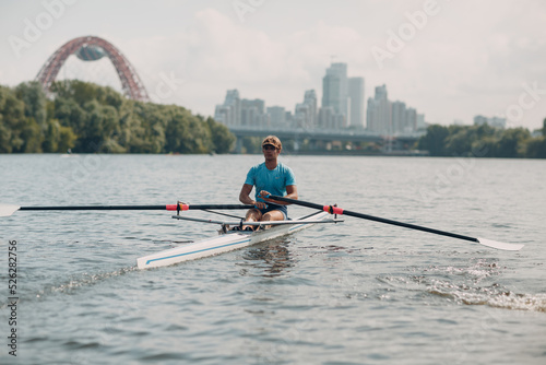 Sportsman single scull man rower rowing on boat at Moscow River Russia