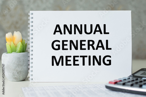 On a light background, a white notebook with are words AGM Annual General Meeting