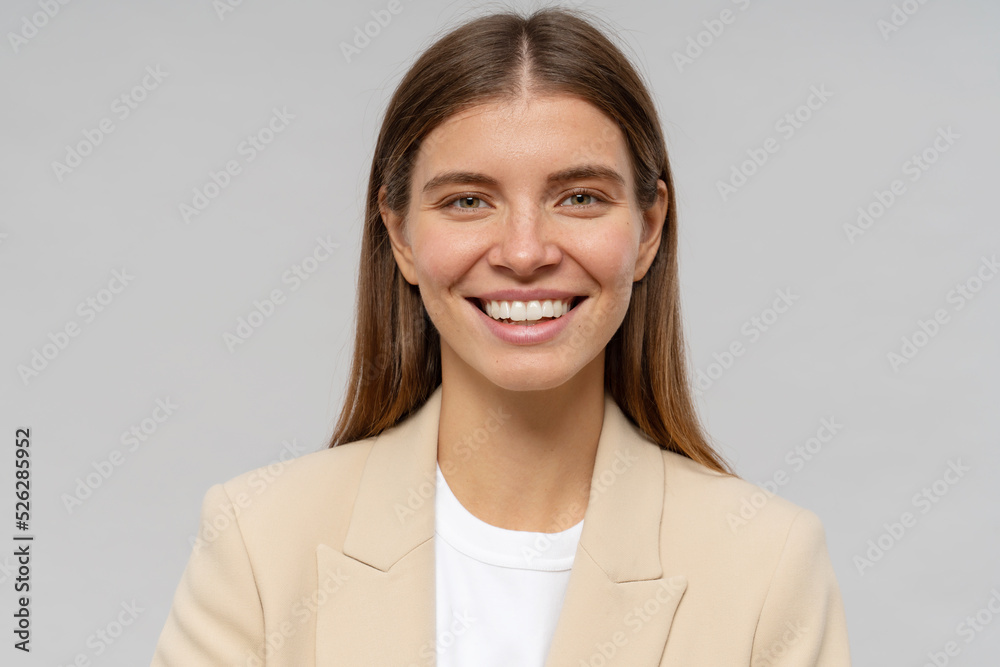Headshot portrait of smiling woman teacher looking at camera on gray background Headshot portrait of smiling woman teacher looking at camera on gray background