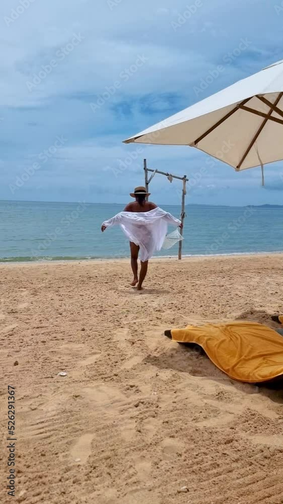 Women on a beach bed on the beach in Pattaya in Thailand Ban Amphur