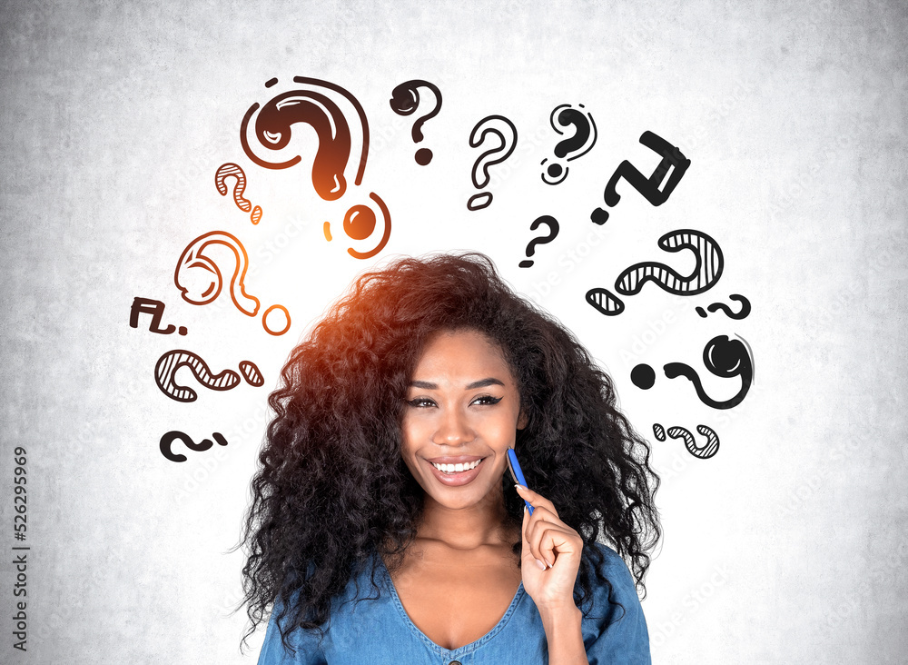 African woman with a dreaming look, question marks on grey wall African woman with a dreaming look, question marks on grey wall