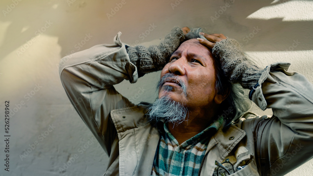 Close Up The face of a dirty-dressed, long-haired, long-haired old man, who is homeless, is showing signs of serious stress because he has no food to eat and no work to sleep on the streets. Close Up The face of a dirty-dressed, long-haired, long-haired old man, who is homeless, is showing signs of serious stress because he has no food to eat and no work to sleep on the streets.