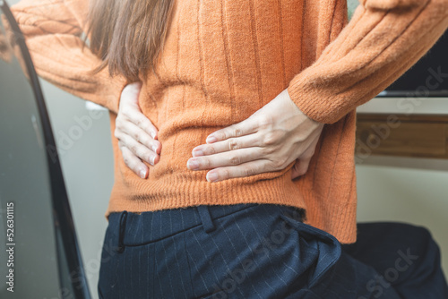 office syndrome, woman with back pain symptoms during work in the office. photo