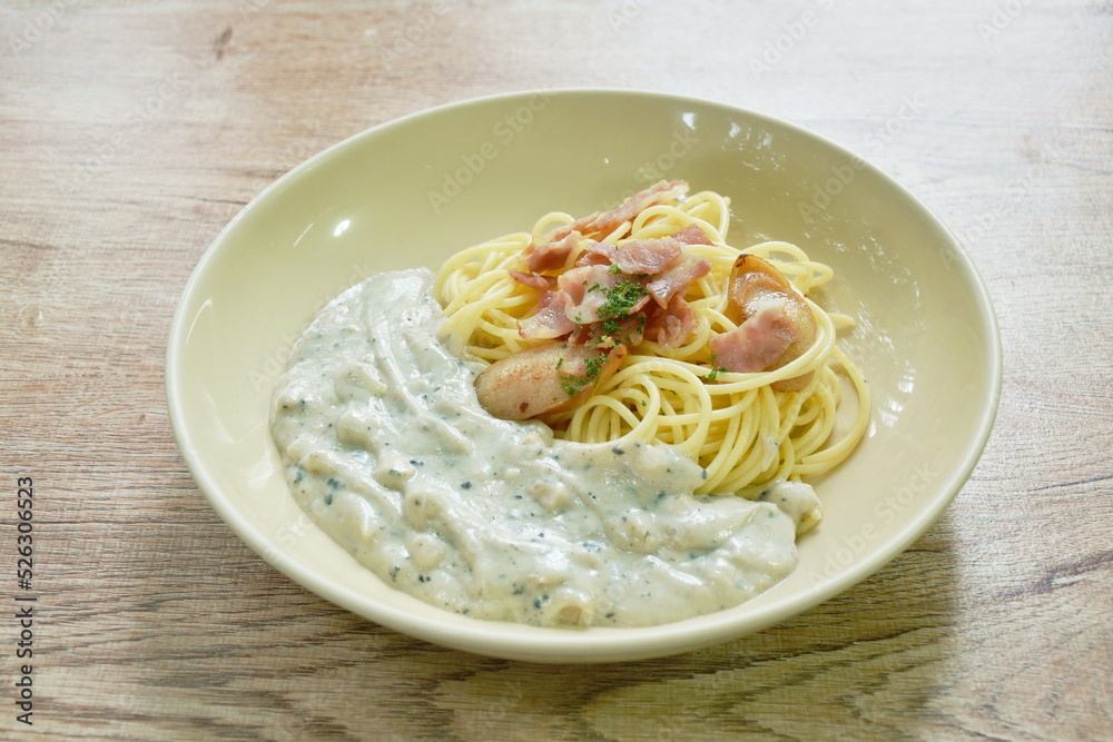 steamed spaghetti with white truffle mushroom cream sauce topping slice pork sausage and bacon on plate steamed spaghetti with white truffle mushroom cream sauce topping slice pork sausage and bacon on plate