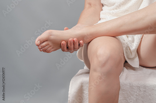 Close-up view of foot in female hands. Female legs. Reflexology. Self-massage of the feet. photo