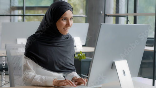 Foto Excited joyful businesswoman sitting at workplace in office receiving email on c