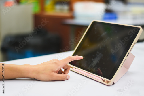 Close-up of Asian woman's hand pressing a tablet