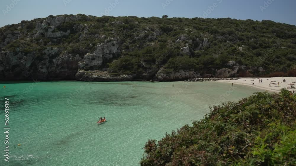 Boats on turquoise water and beach at Cala en Porter, Menorca, Balearic Islands