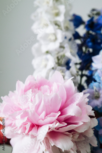 delicate bouquet of delphiniums and large pink peony